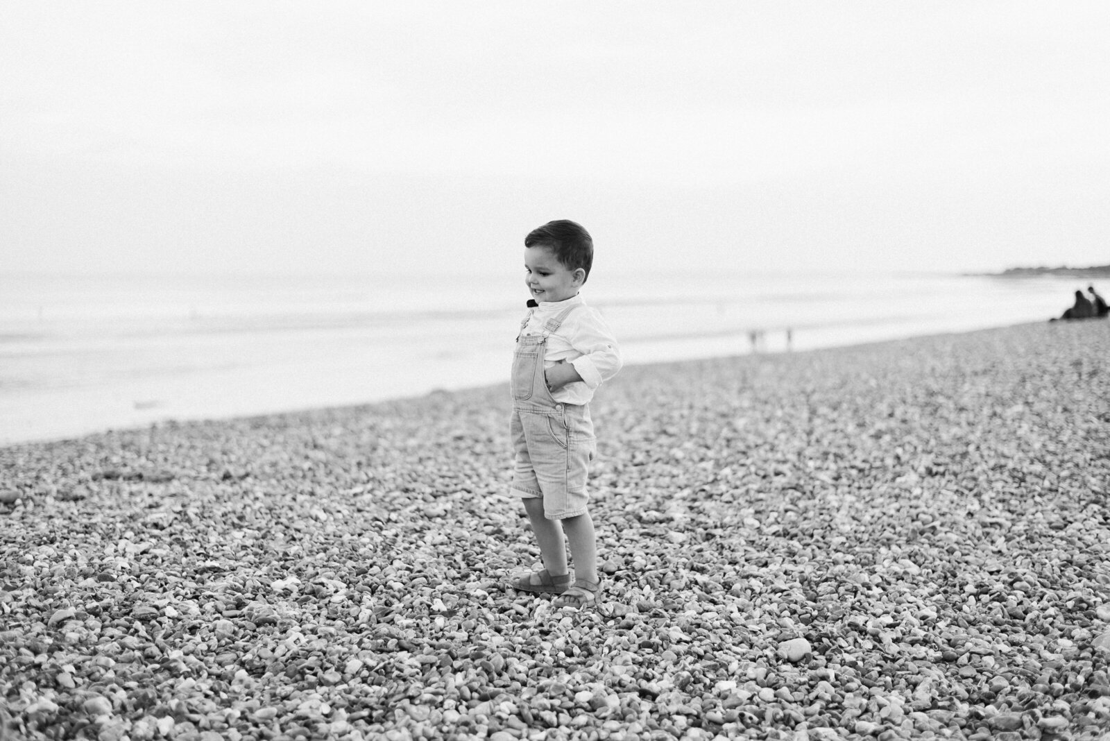 A little boy standing on the beach at family photoshoot in Billingshurst