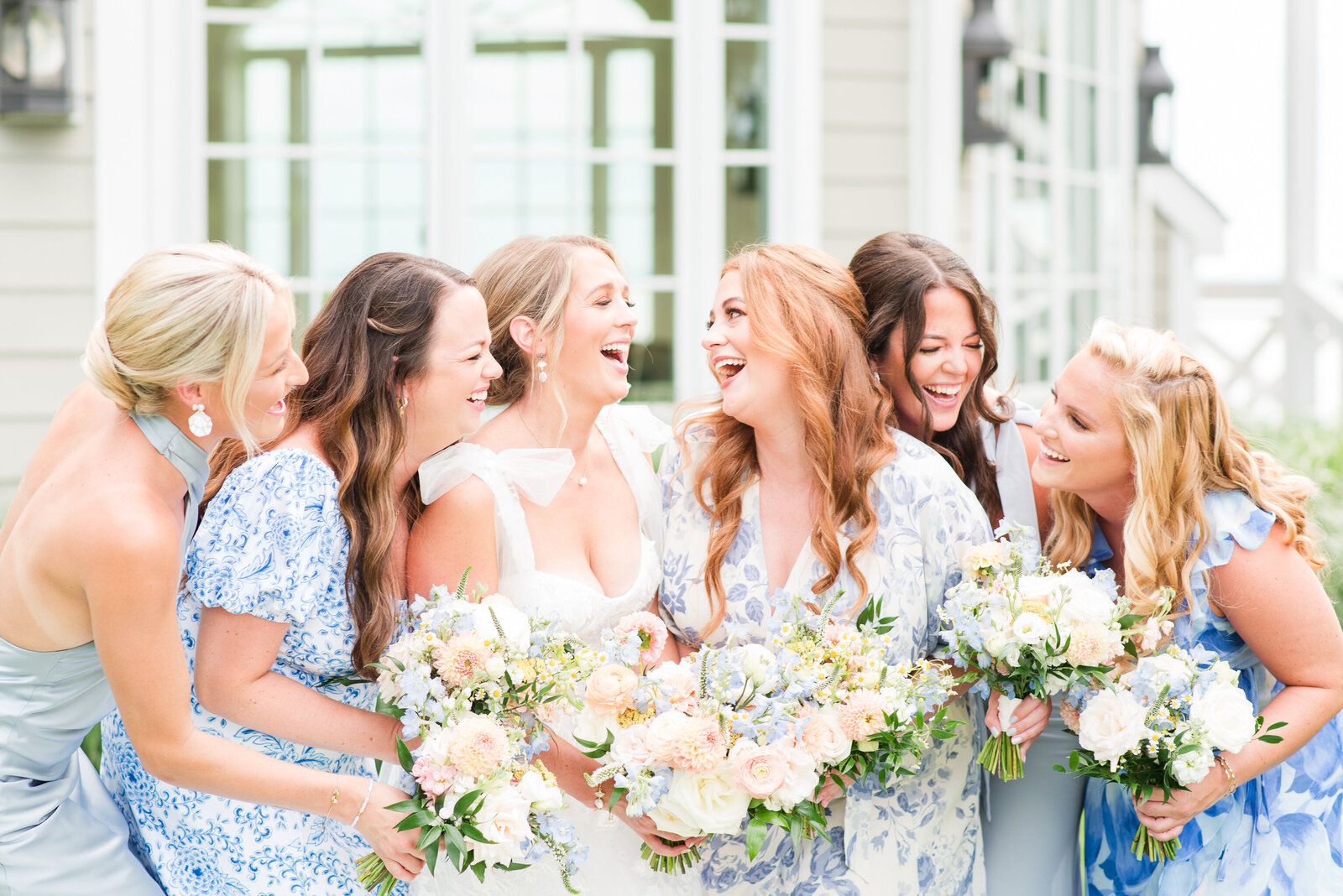 bridesmaids with mismatched blue floral dresses and peach florals