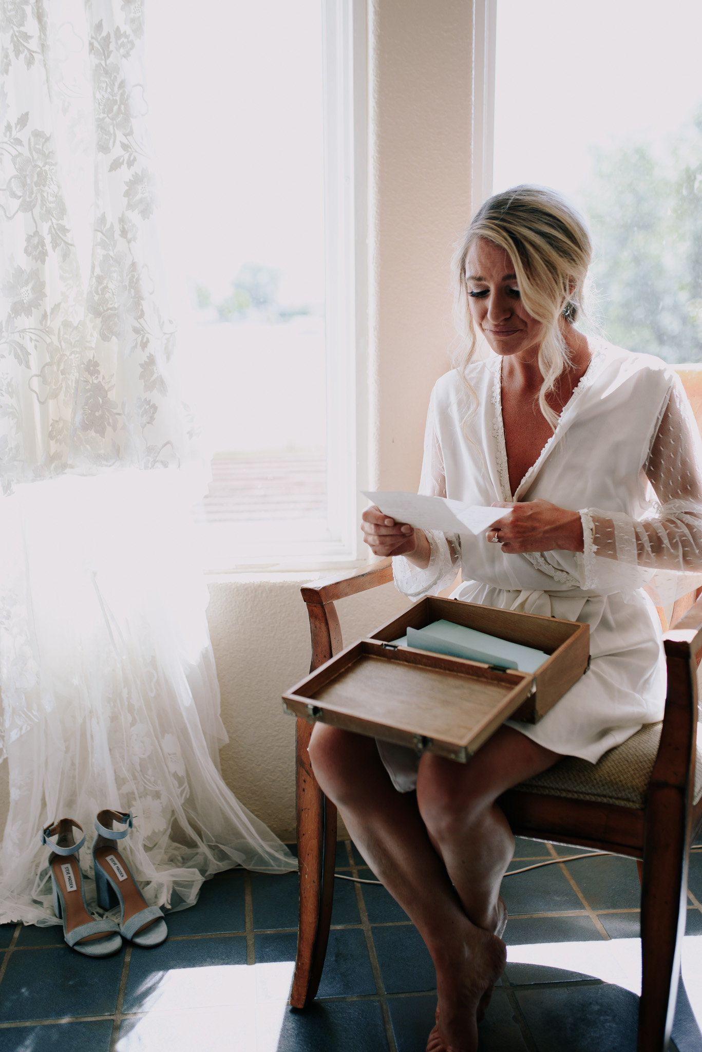 Bride opening a touching gift before her wedding in her bridal suite at a Winery in Wyoming.