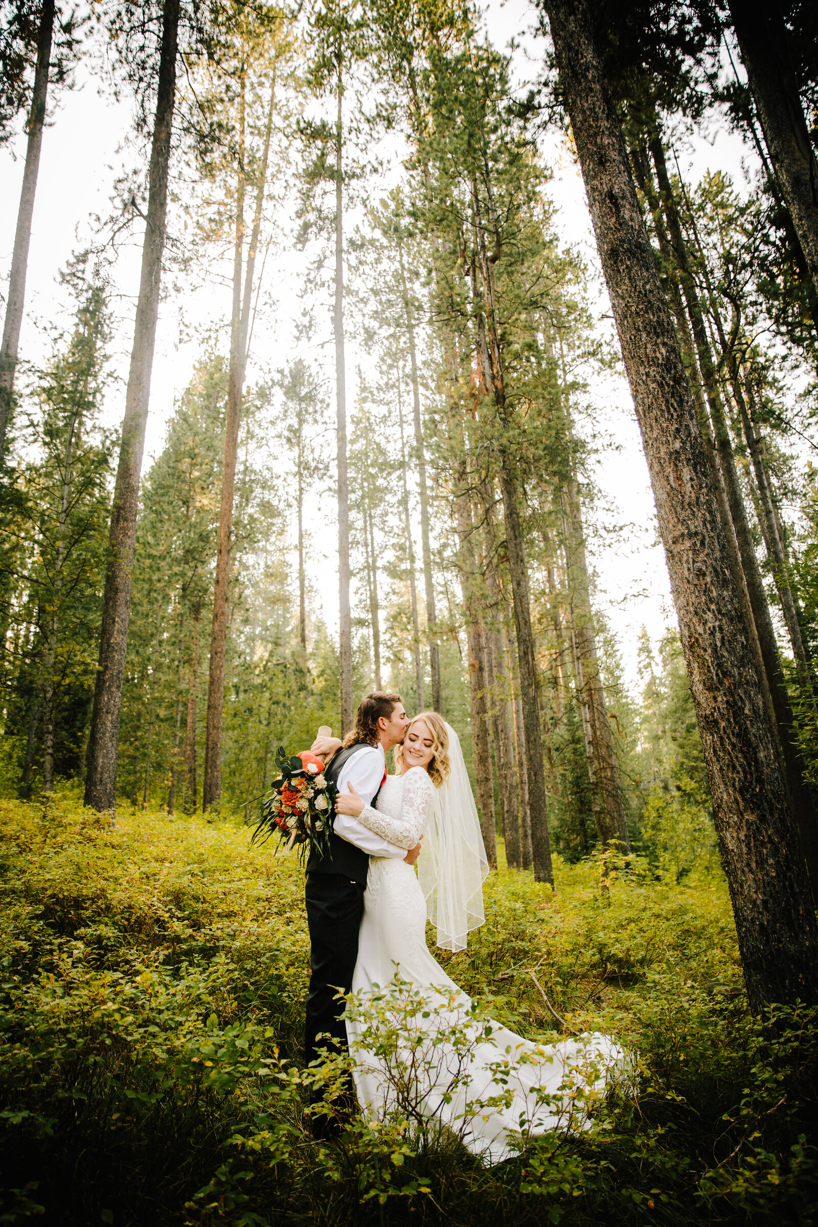 Jackson Hole photographers capture couple in forest during golden hour portraits
