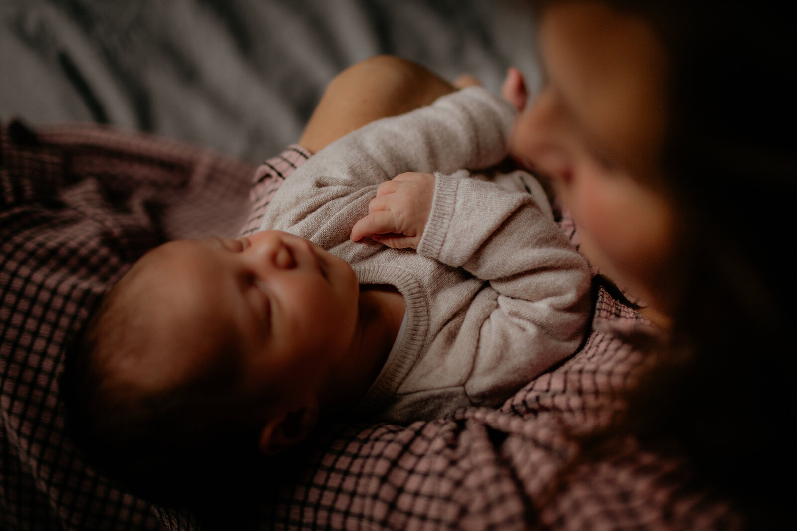 Baby slapend in armen van mama tijdens newbornshoot