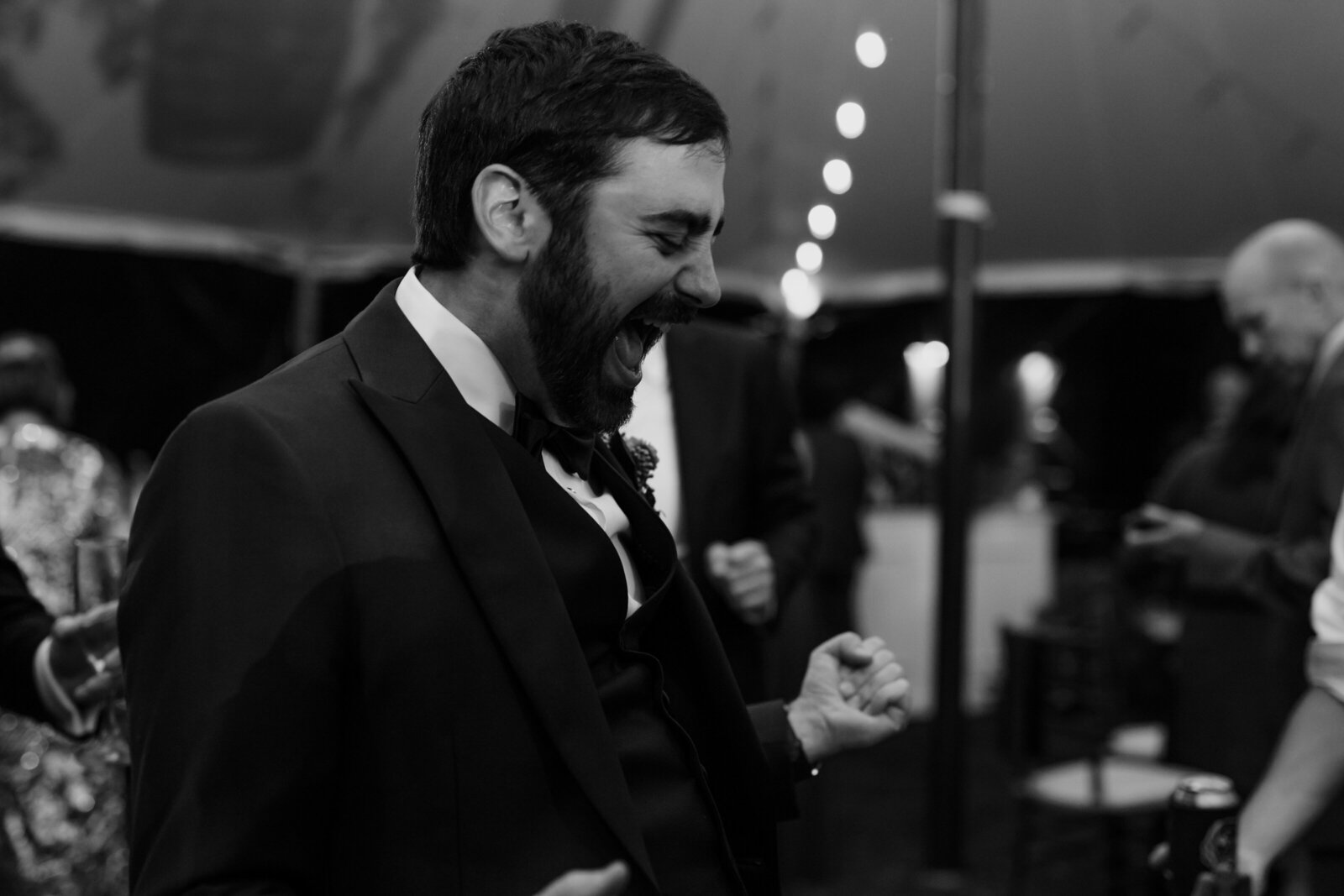 A groom dances and sings during a wedding reception