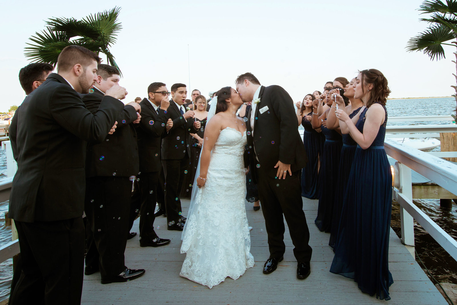 Bride and groom kissing with bridal party