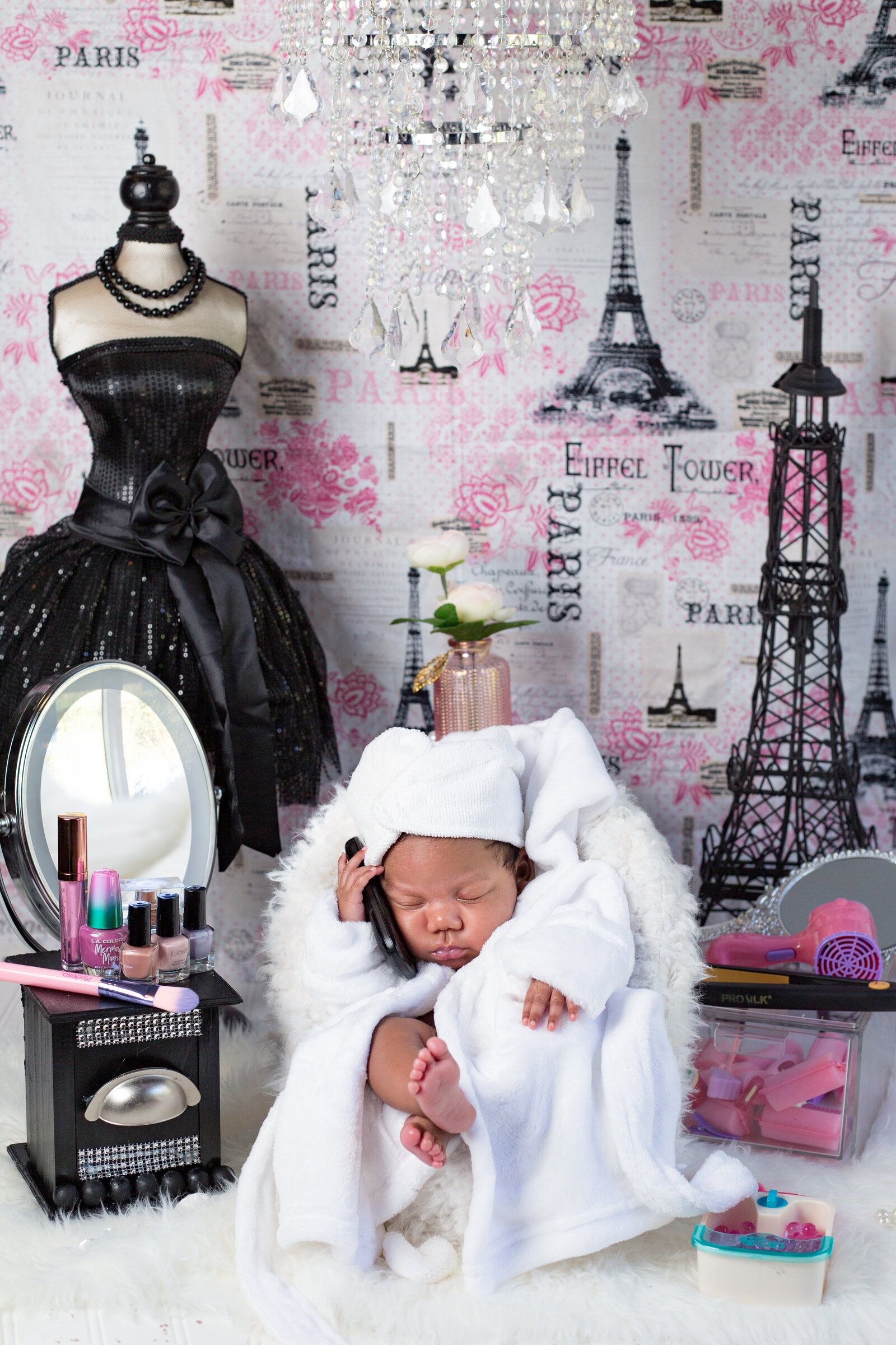 newborn on the phone with legs crossed with Eiffle Tower. hair & nail accessories,  and dressed bodice  whatnots
