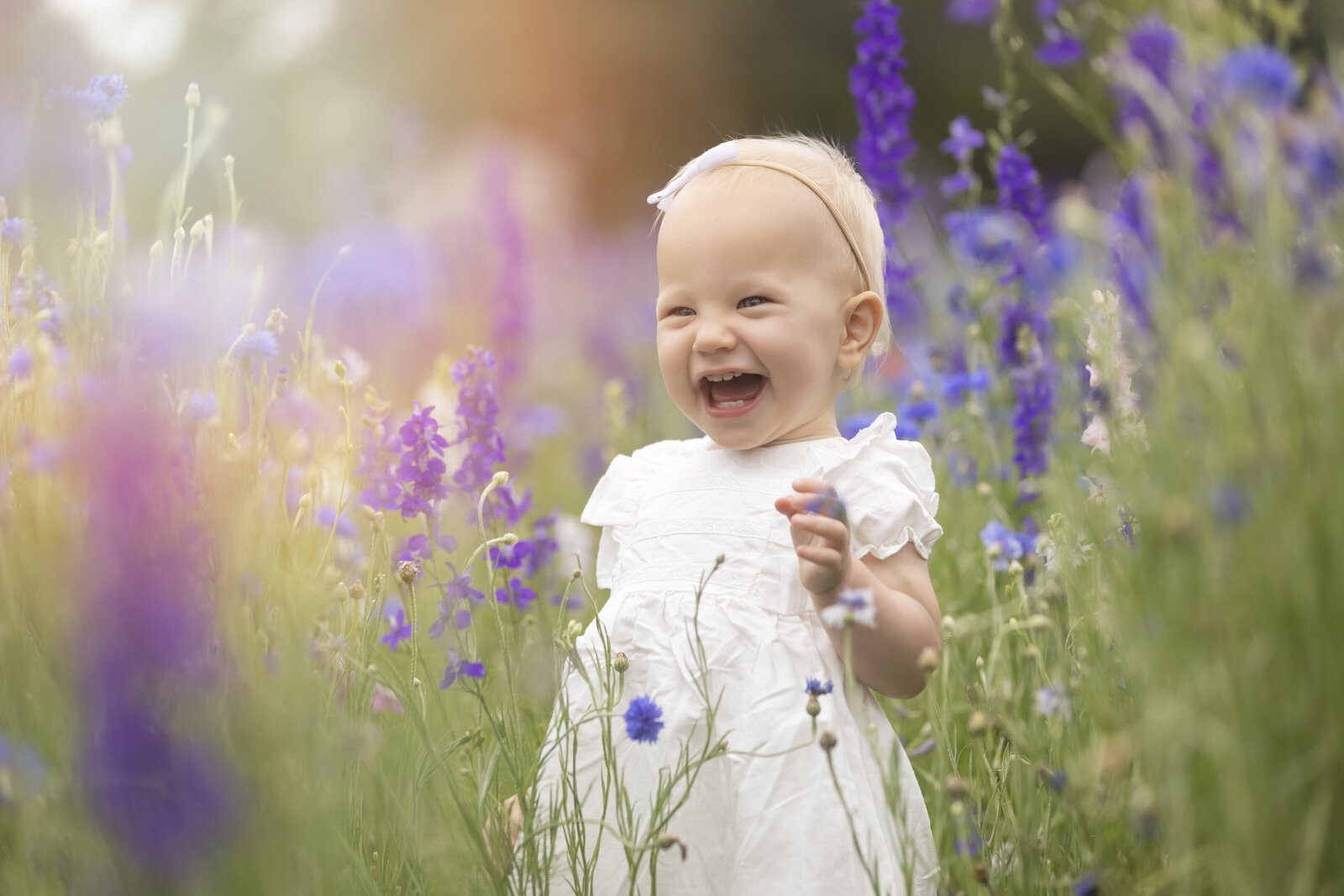 Toddler laughing in wildflowers photos