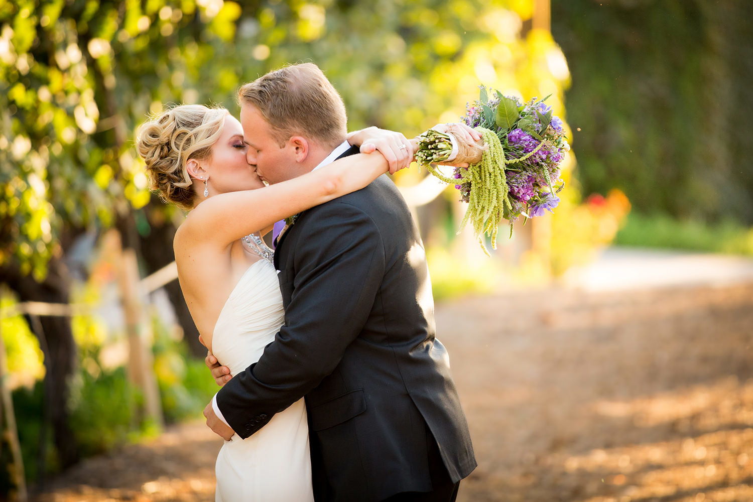 bride and groom kissing in the vineyard