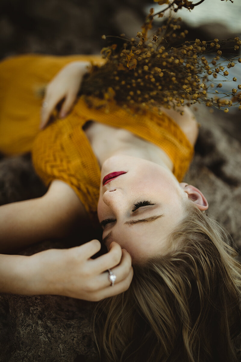 girl with floral bouquet poses during senior photo session