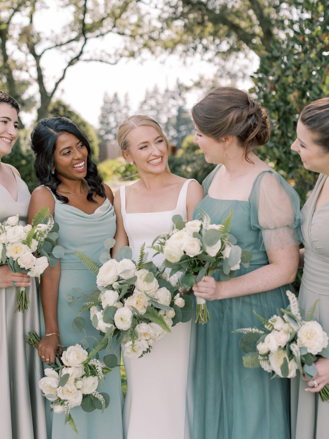 Bride with her bridesmaids wearing green themed dress