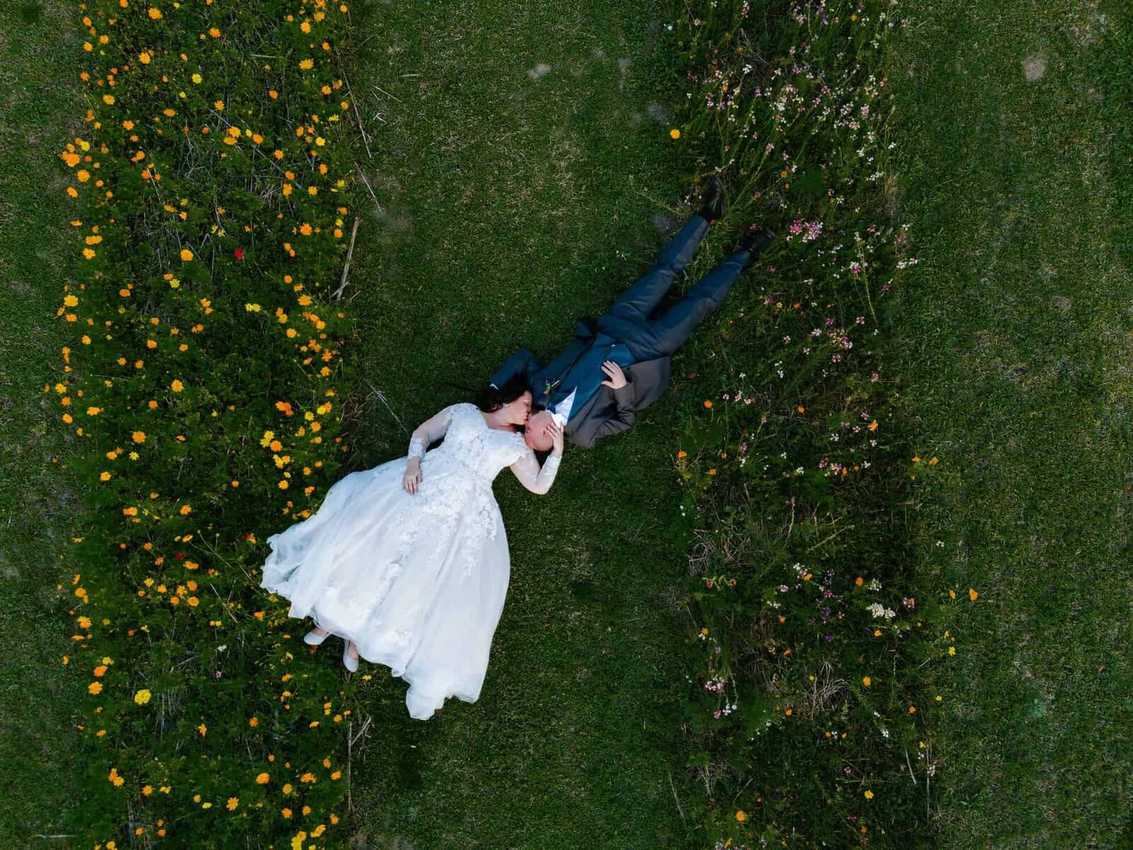 Ever after farms flower barn wedding - drone photo of the couple laying in a flower field