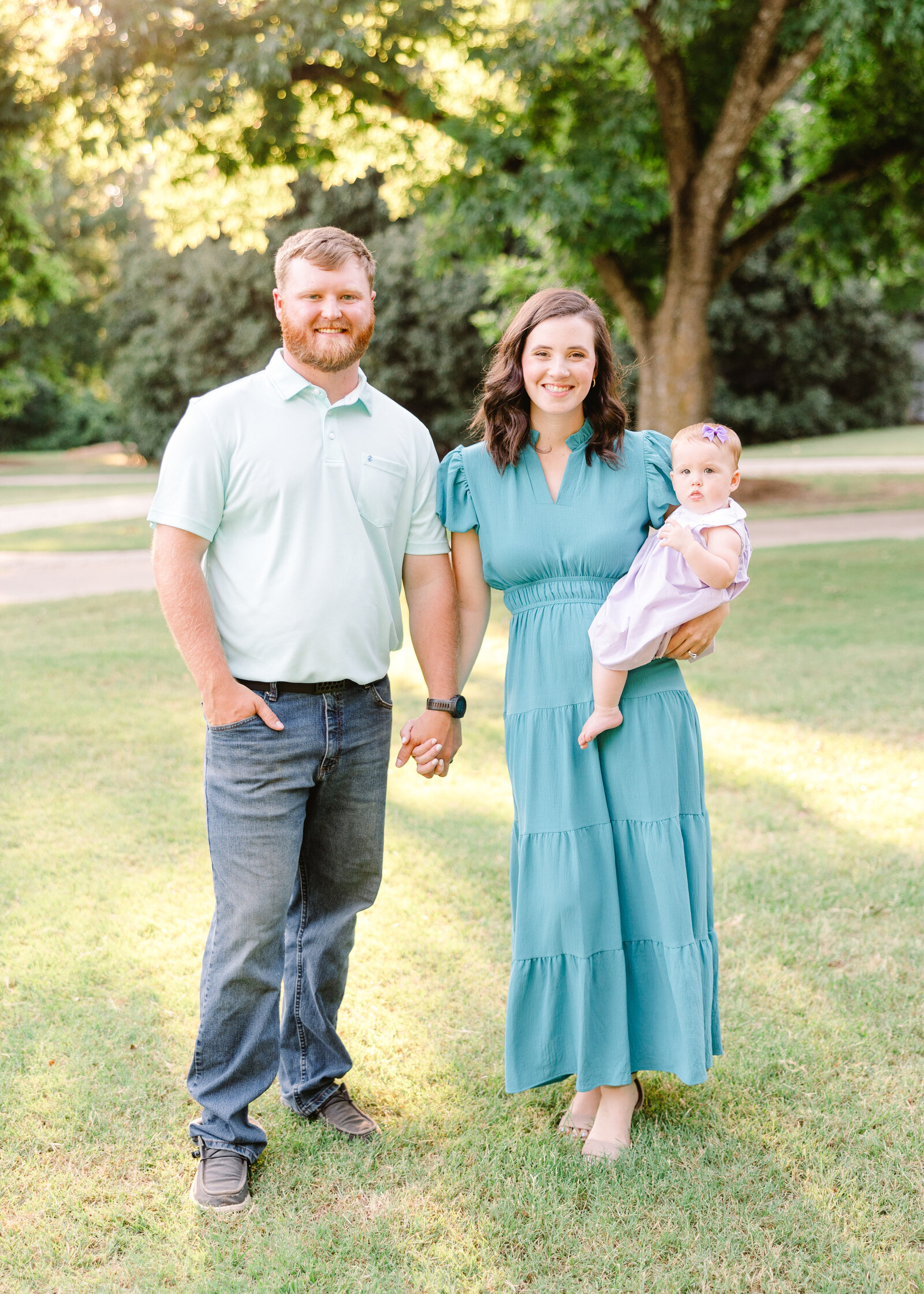 The Wares Family standing together in a park, dressed in coordinated blue tones, photographed by Abby Bell Photography, Fine Art Portrait Photographer based in Alabama.