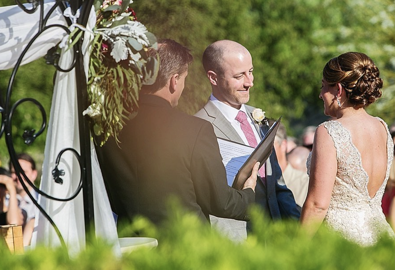 Groom smiles while taking his wedding vows