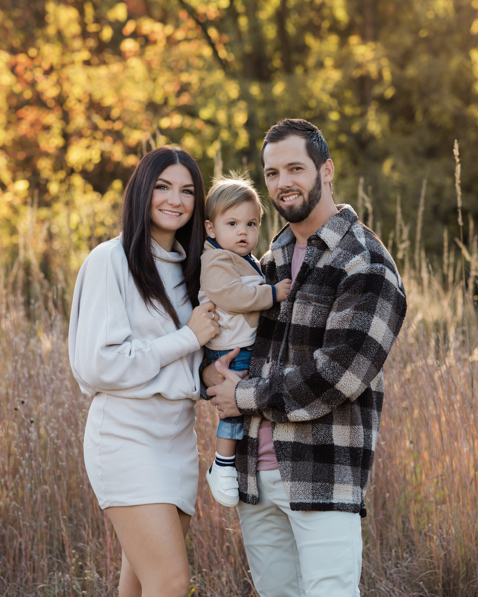 mom and dad holding son for family photos 