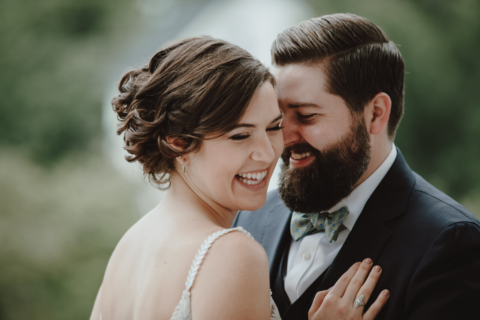 A bride and groom face each other and laugh