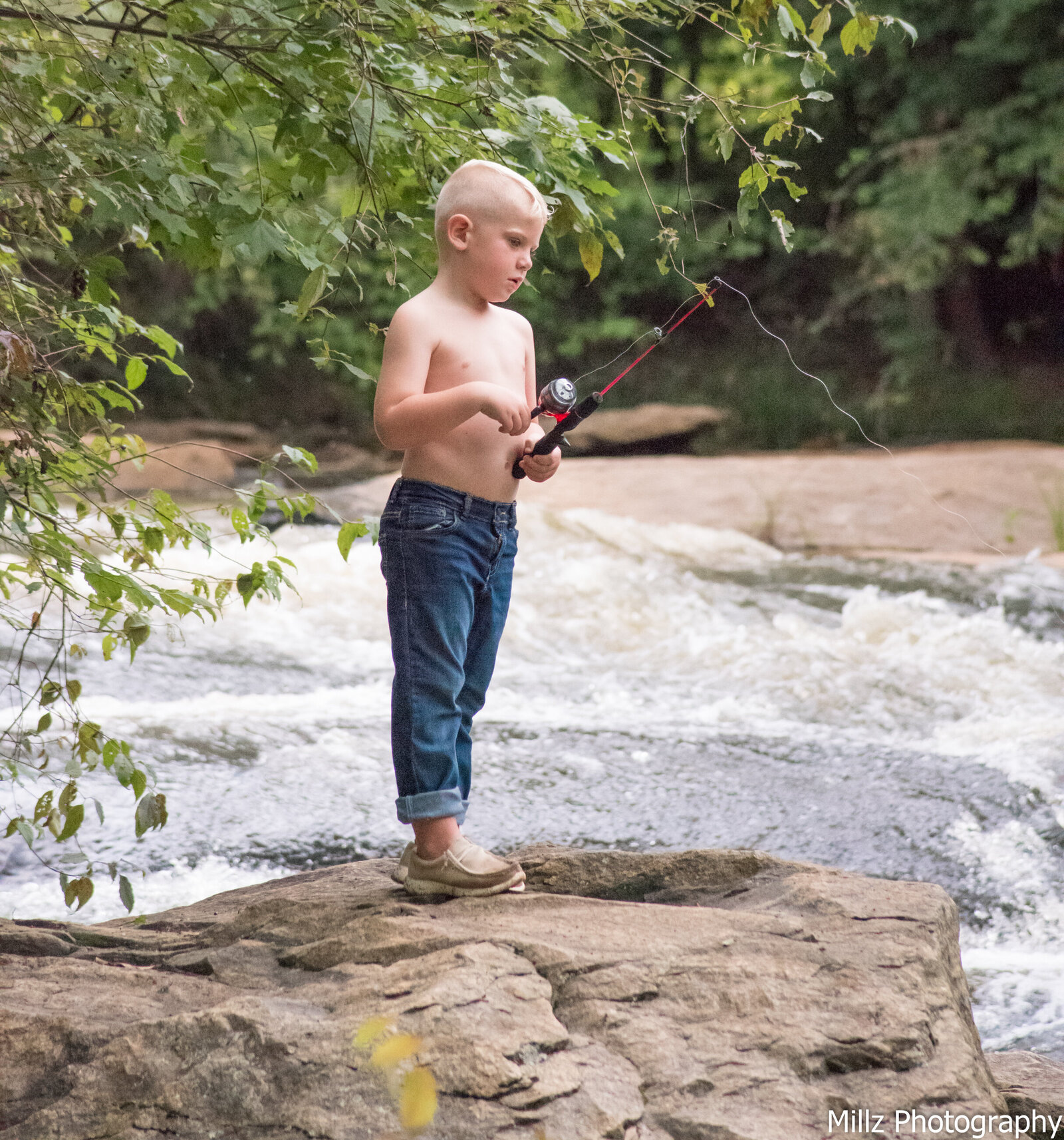 young white boy fishing near a river photographed by Millz Photography in Greenville, SC