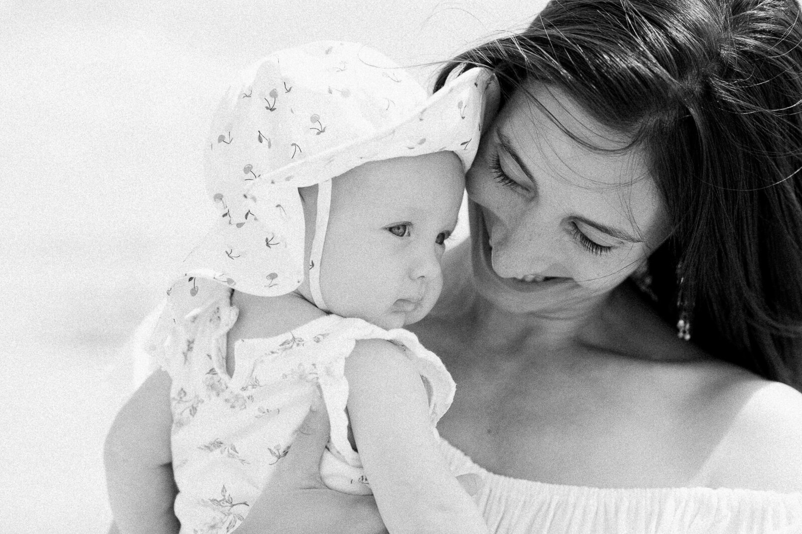 mom snuggle baby on beach