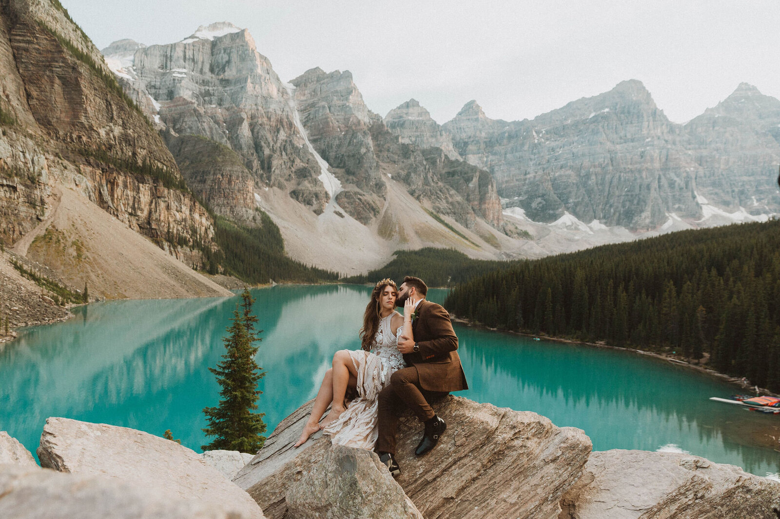 eloping couple kissing with Alberta mountains background