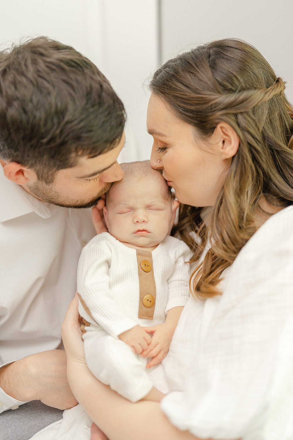 parents kissing baby during newborn session in Arlington, Virginia