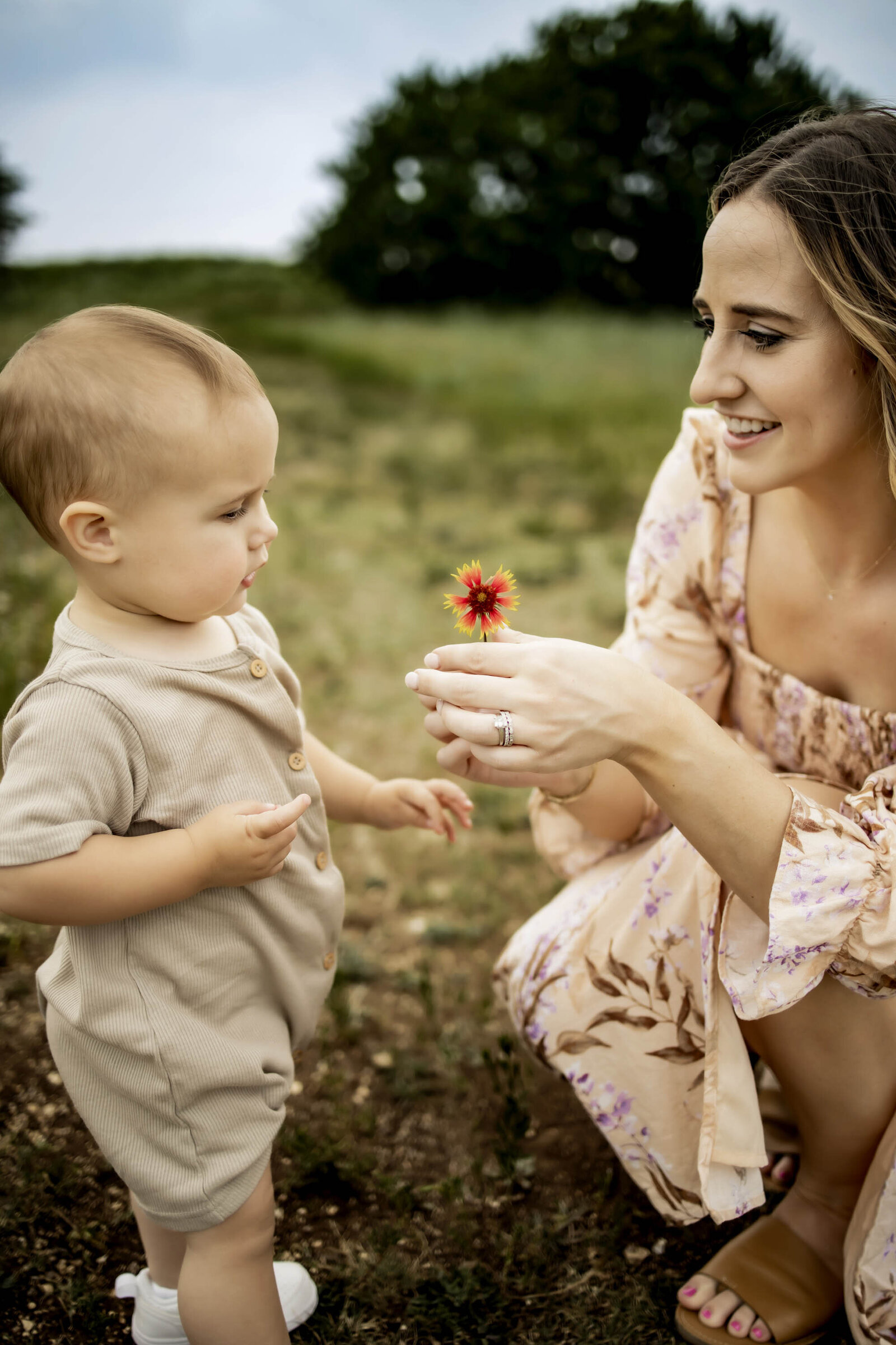 mom and toddler son with a wild flower