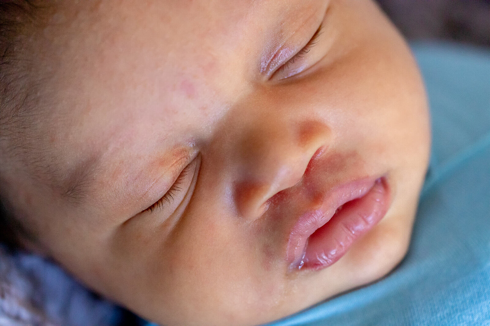 A close-up of a newborn's face during an in-home Woodbridge newborn session.
