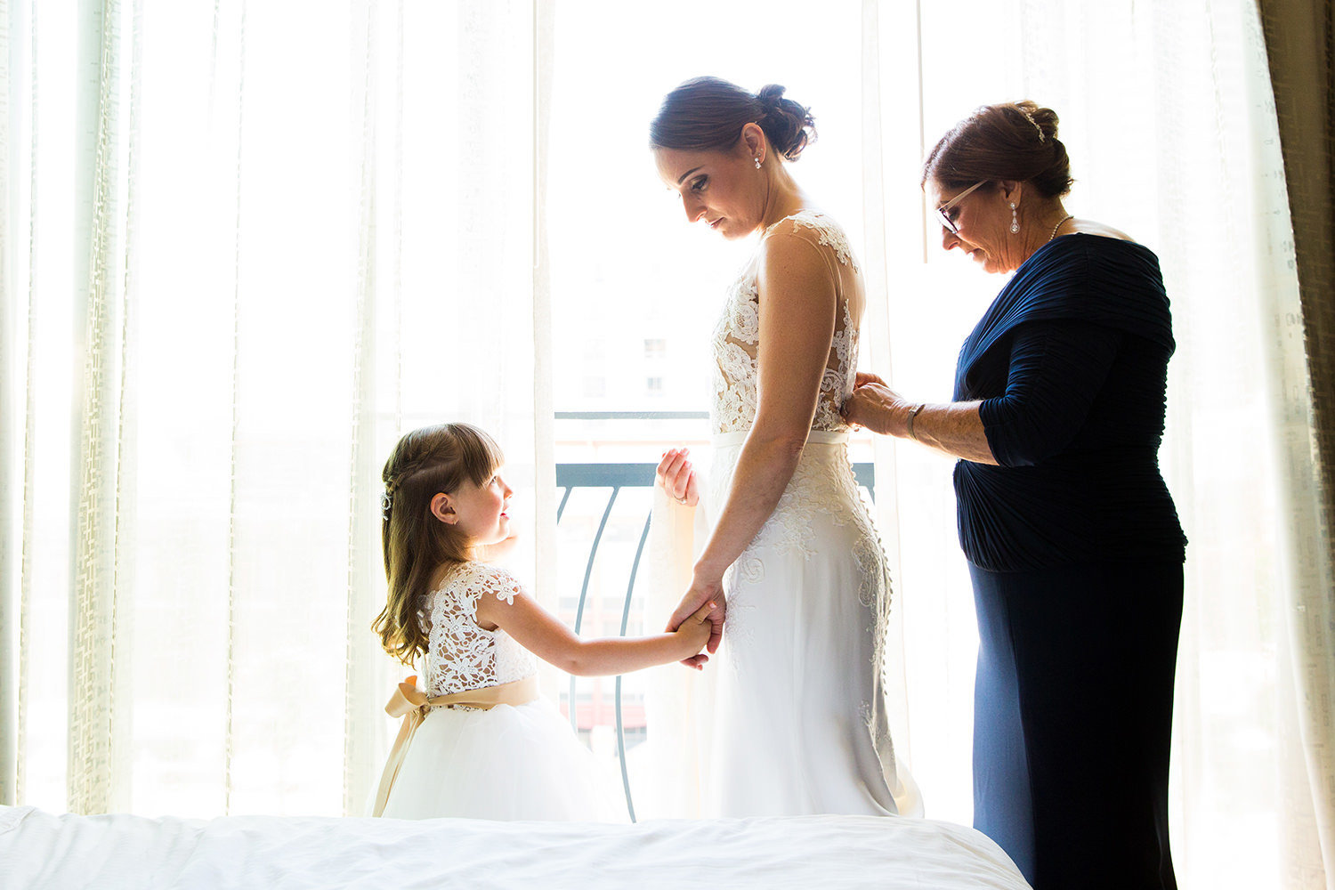 Beautiful moment between the bride and her mother and flowergirl