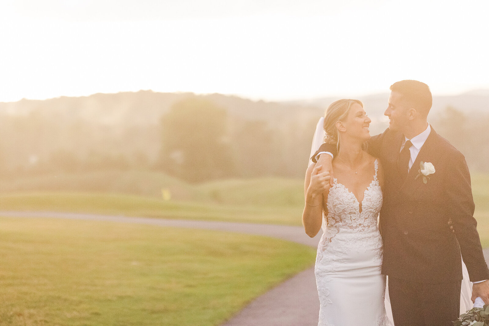 Bride and groom walking hand-in-hand through light fog outside SkyView Golf Club