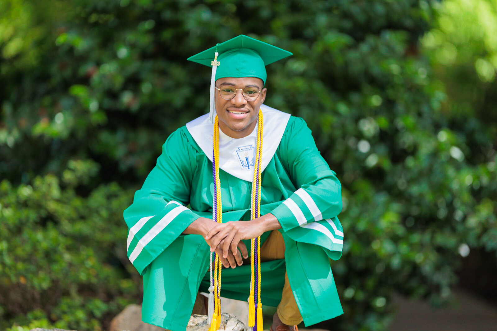 boy in cap and gown bending down