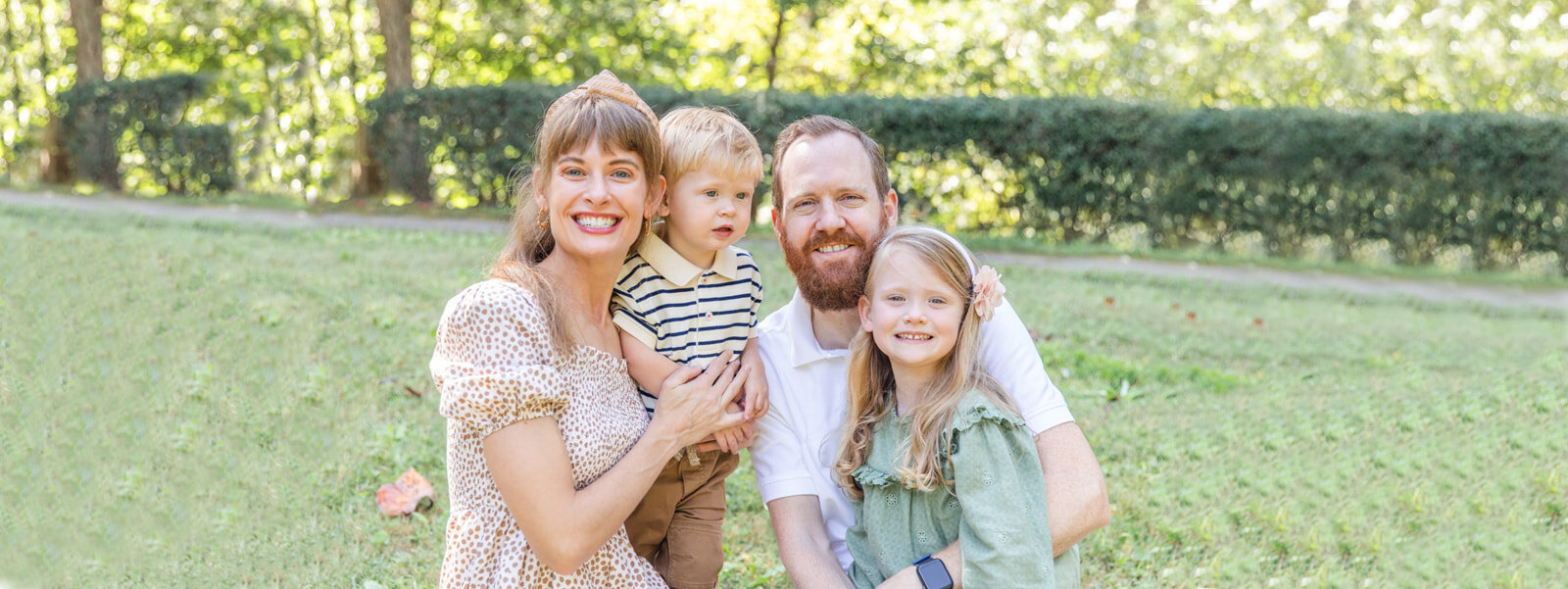 family with toddler sitting in a Buckhead park by Laure photography