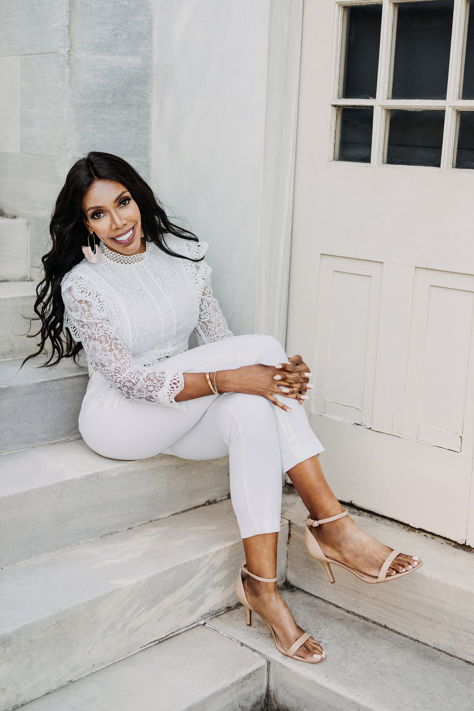 black woman with white pants on marble steps
