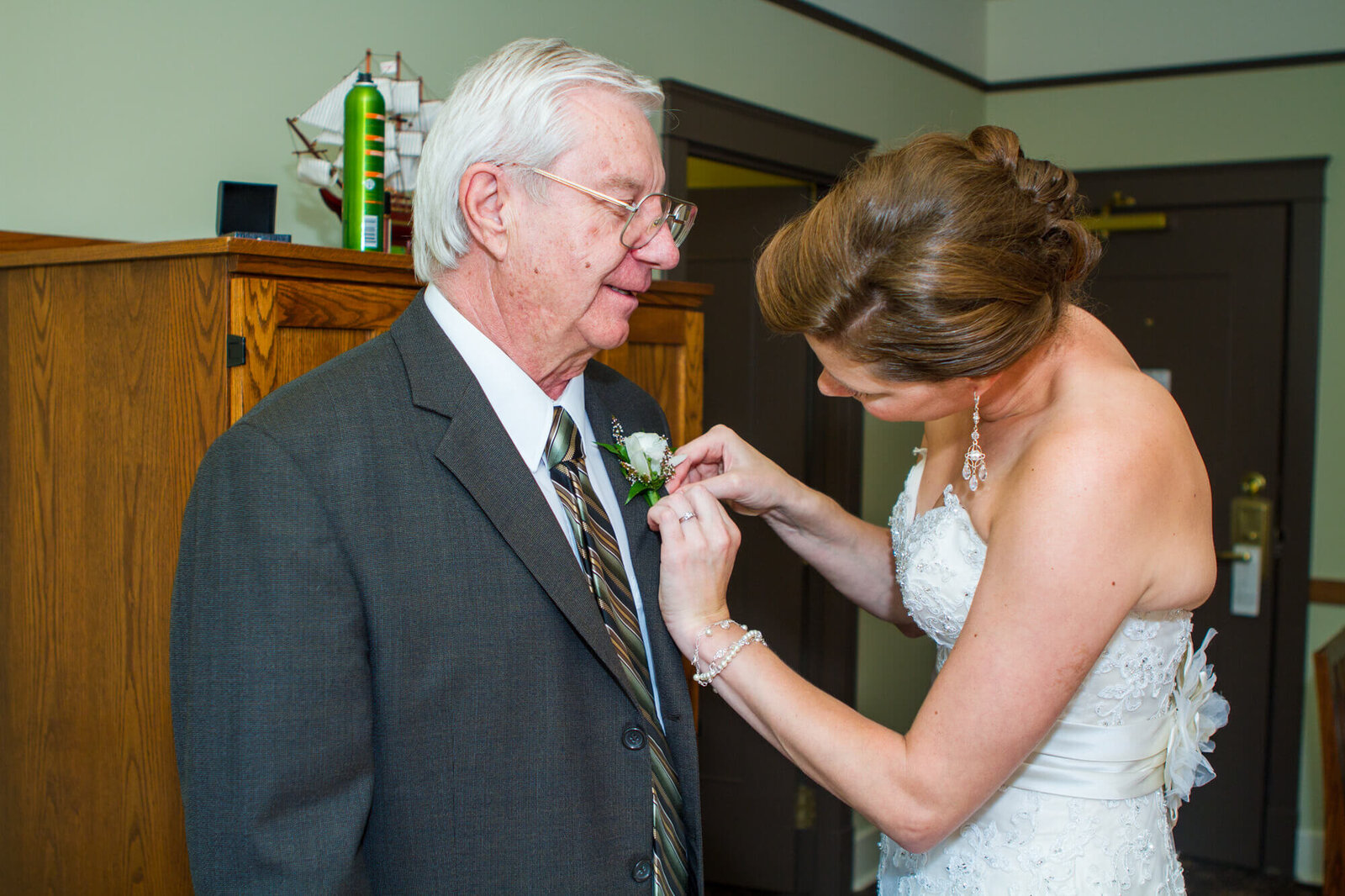 Bride helping father with corsage