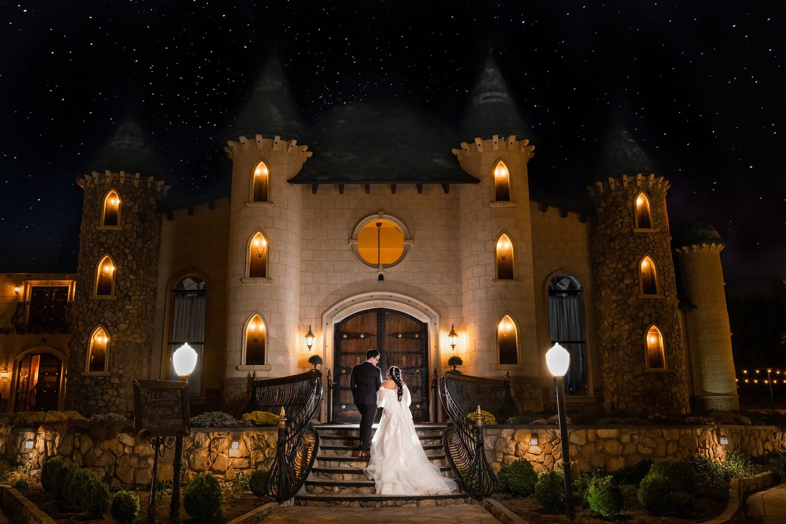 Bride and groom in front of Tuscany barn surrounded by greenery at Wadley Farms