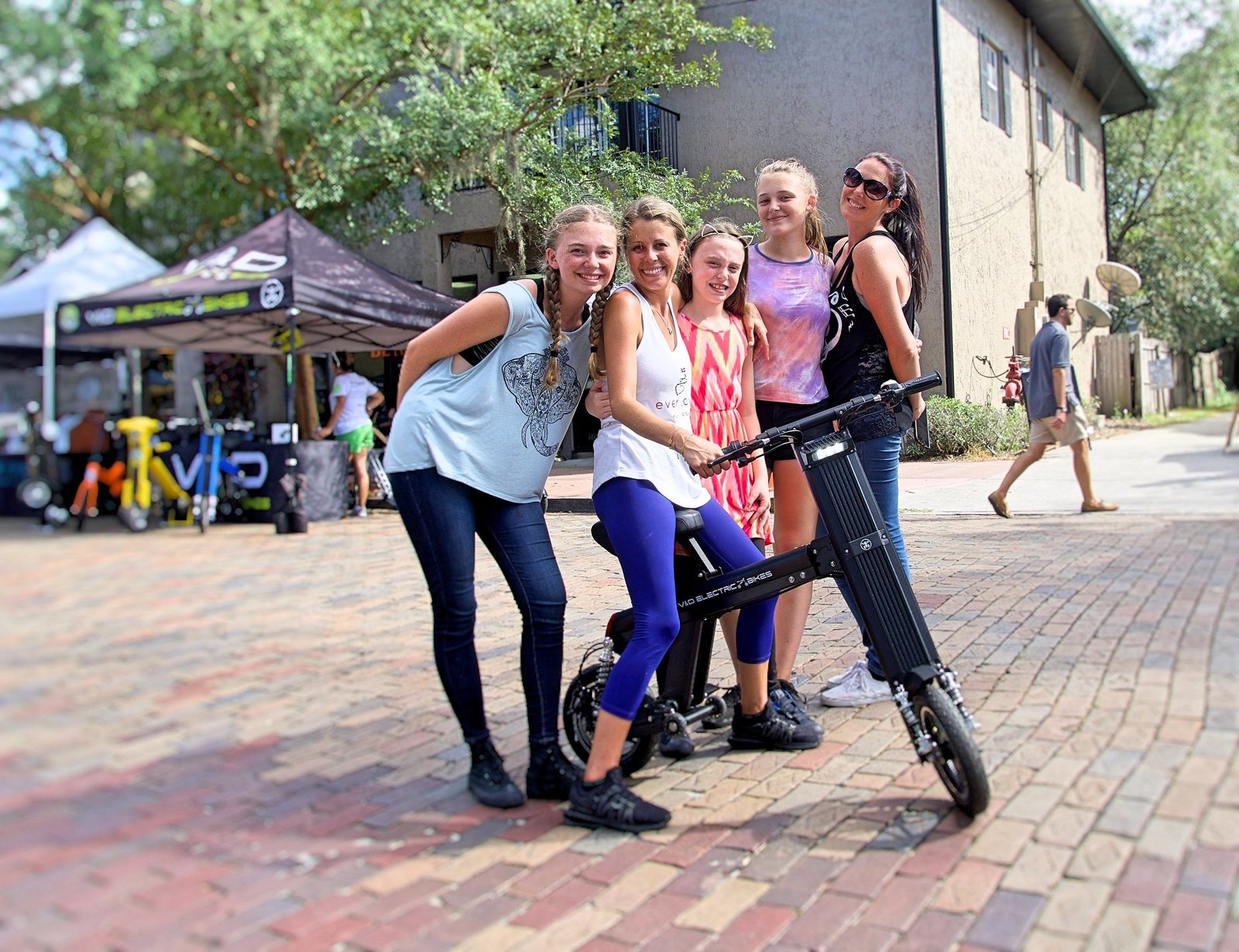 Girls at a local fresh market while taking turns riding a Go-Bike M2