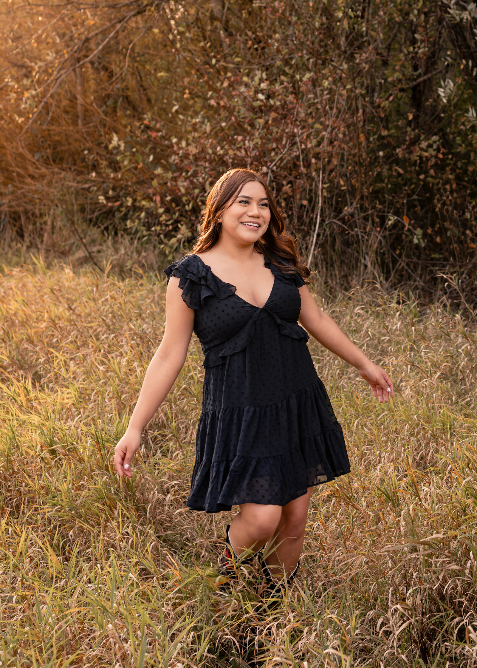 Girl dancing in an open field during golden hour