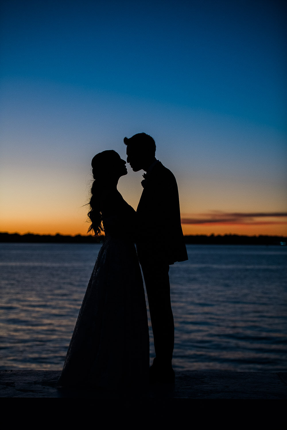 bride and groom silhouette with blue sky and ocean