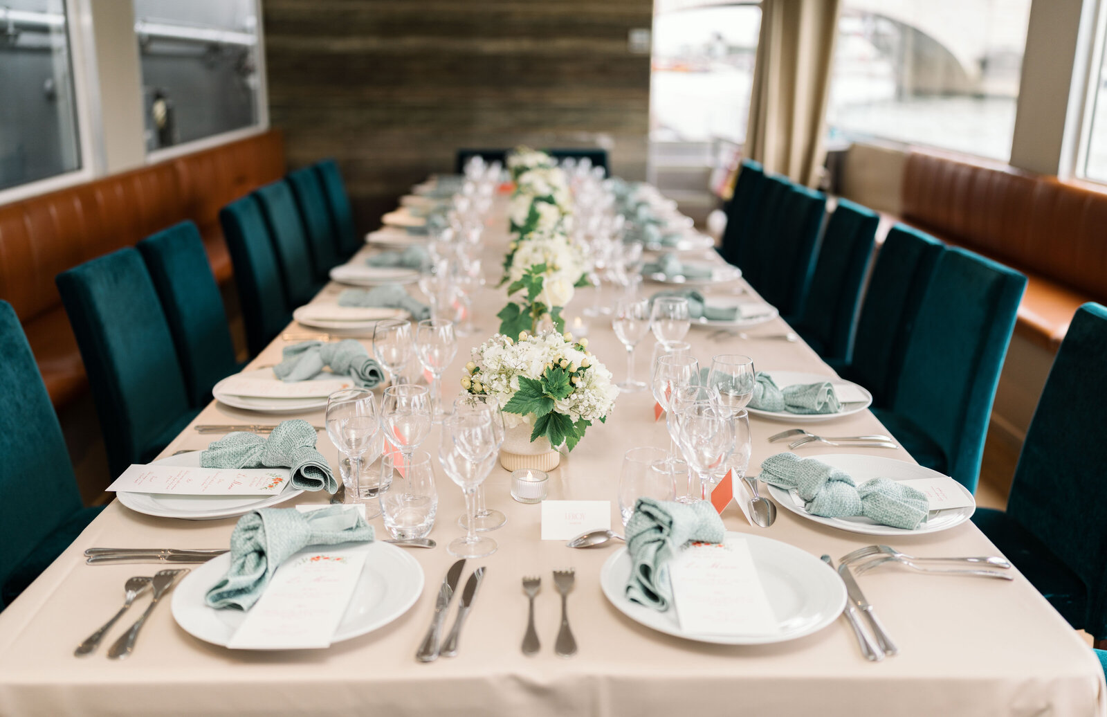 long dining table with blue chairs and napkins