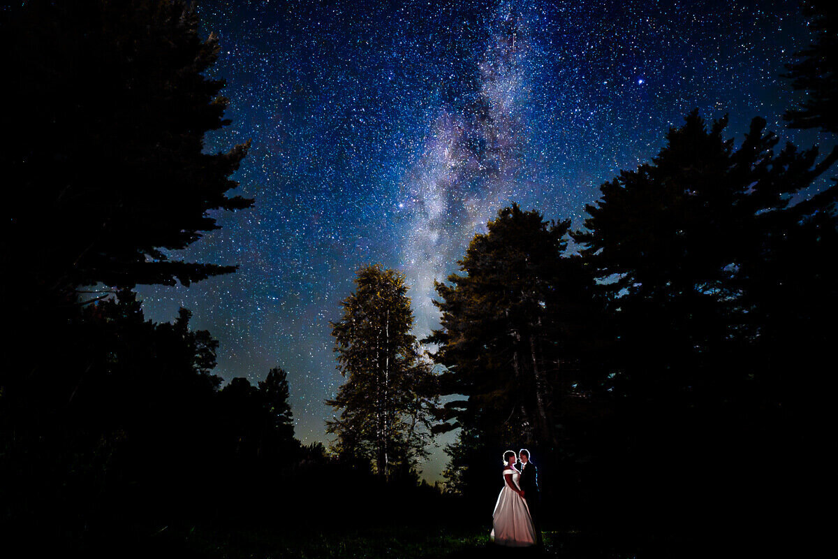 A couple stands under the Milky Way stars during their wedding reception at Sleepy Hollow Inn in Huntington, Vermont, captured by Eaton Photo