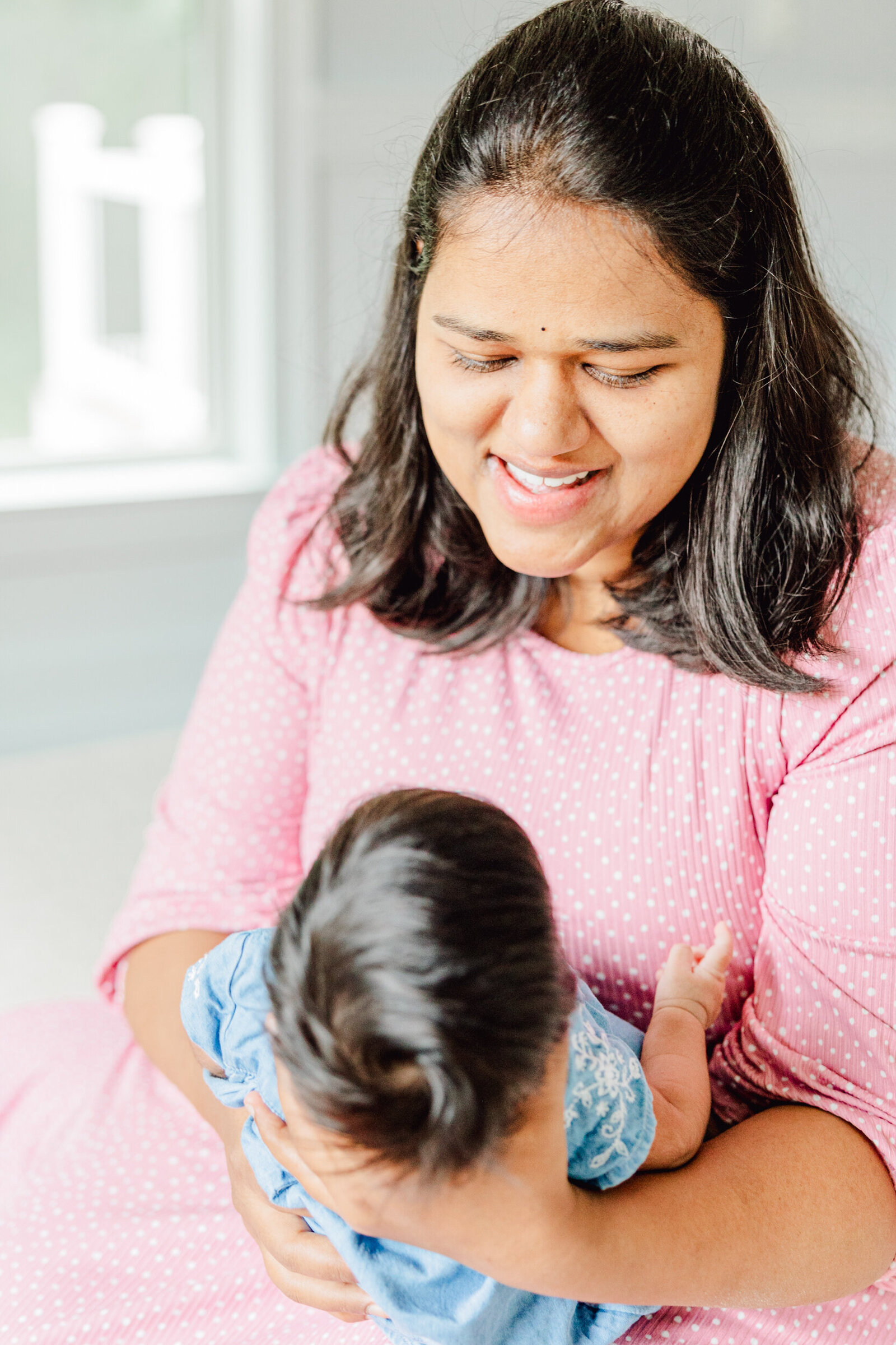 Mom smiles down at her newborn daughter