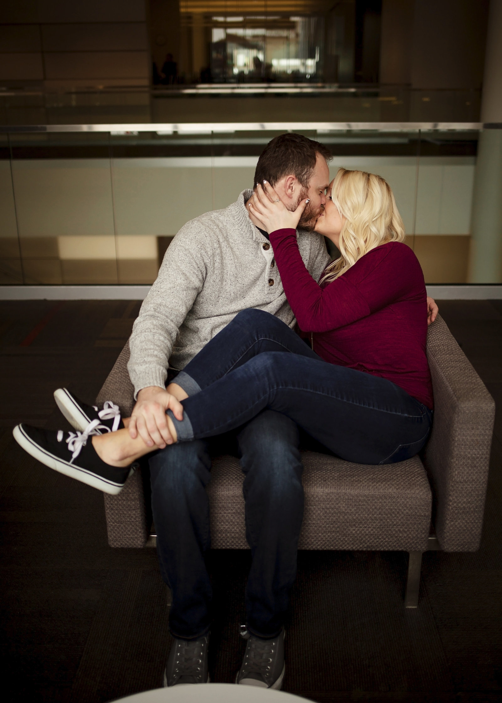 Couple sitting together in a chair kissing.