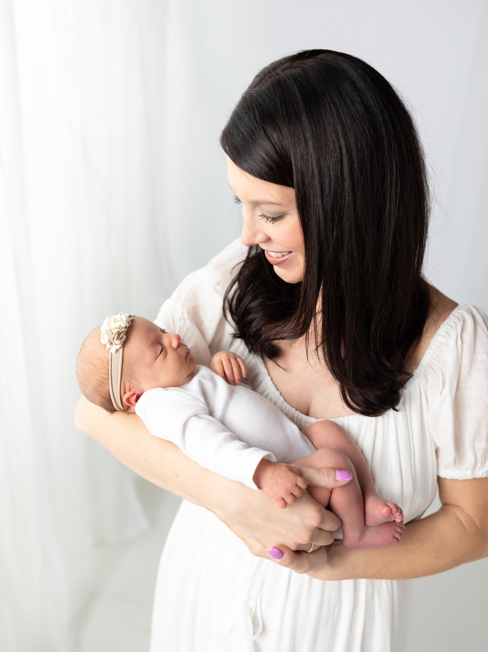 mom holding newborn baby girl for newborn photoshoot cleveland newborn photographer