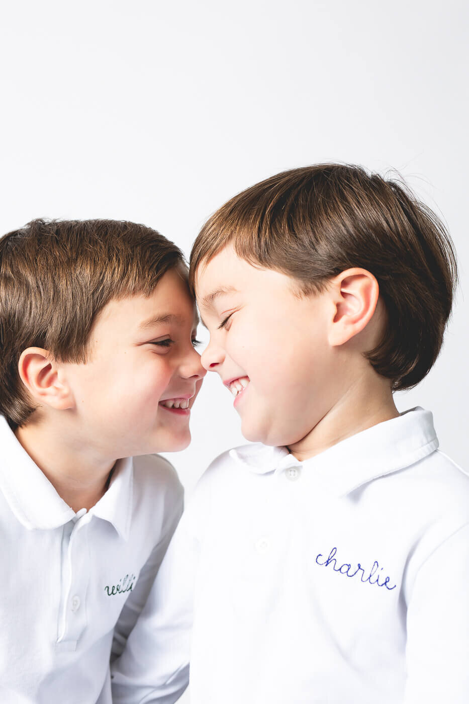 Loving brothers tap their noses together while brightly smiling