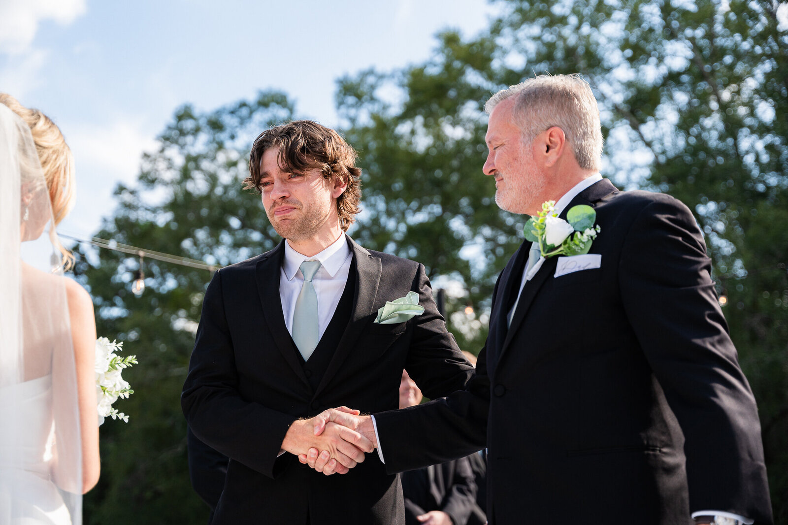 Father of the bride and groom shaking hands
