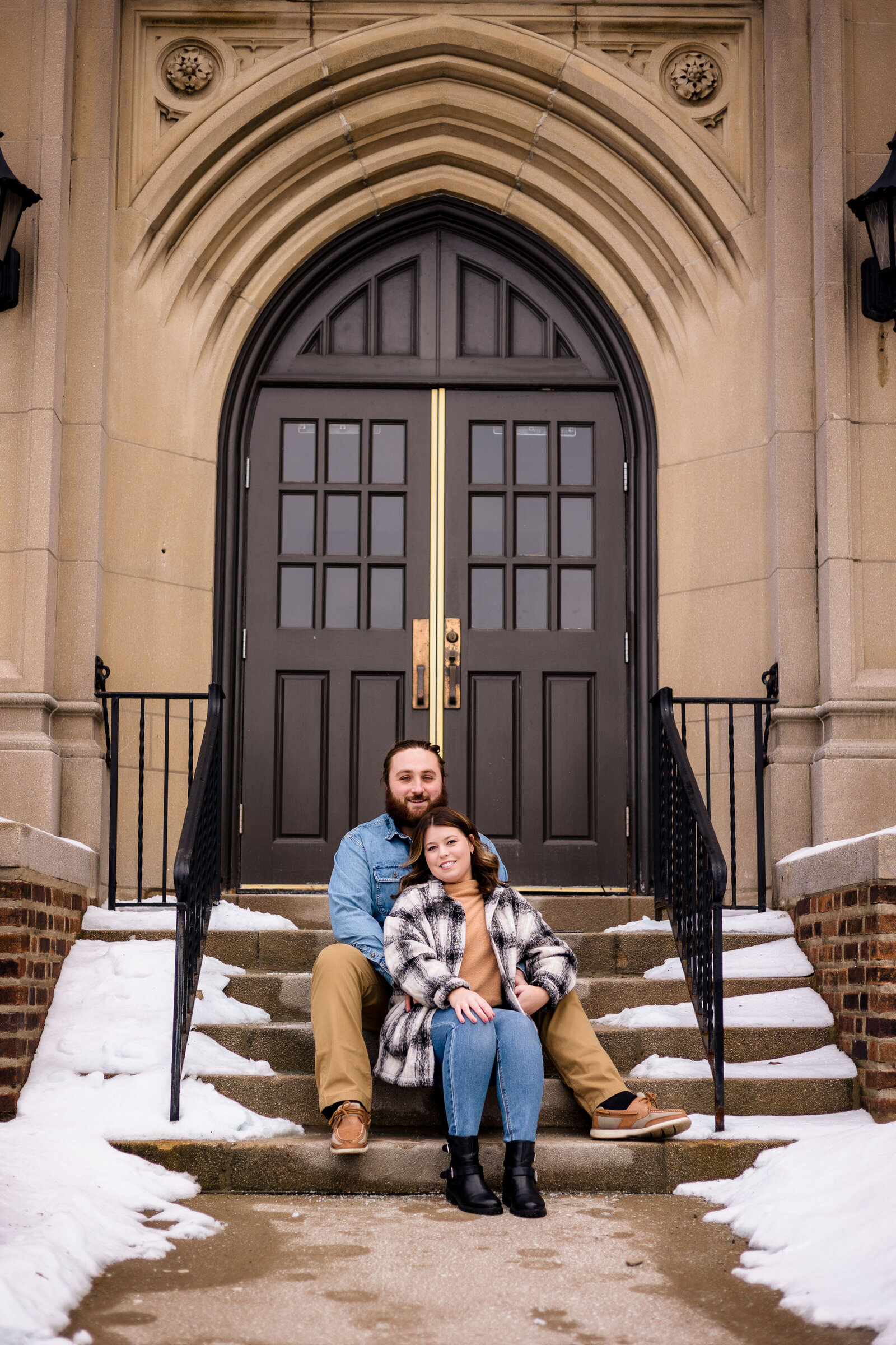 Couple snuggles up on the stairs at Mercyhurst Campus Erie