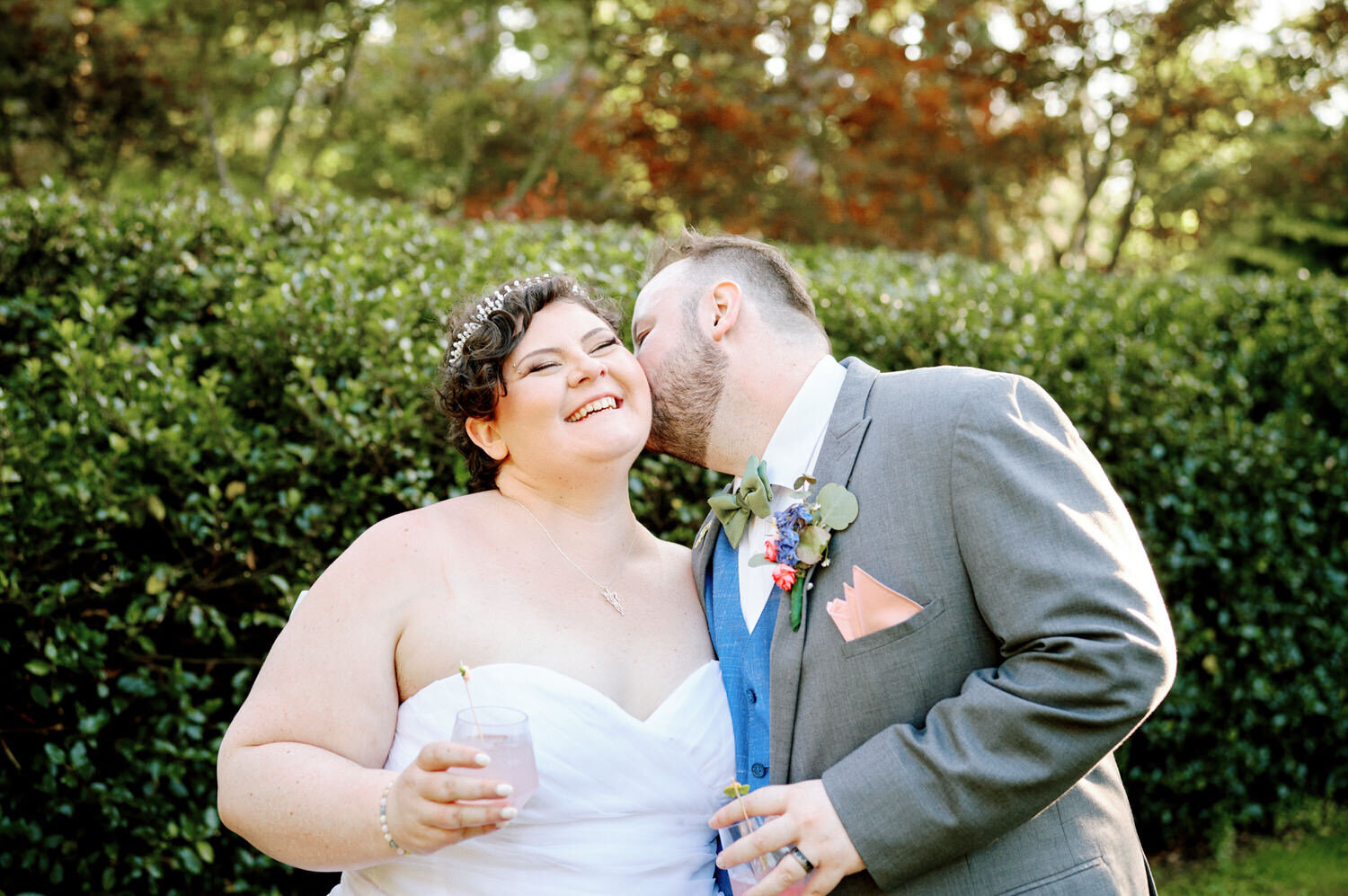 Bride laughs as the groom kisses her cheek