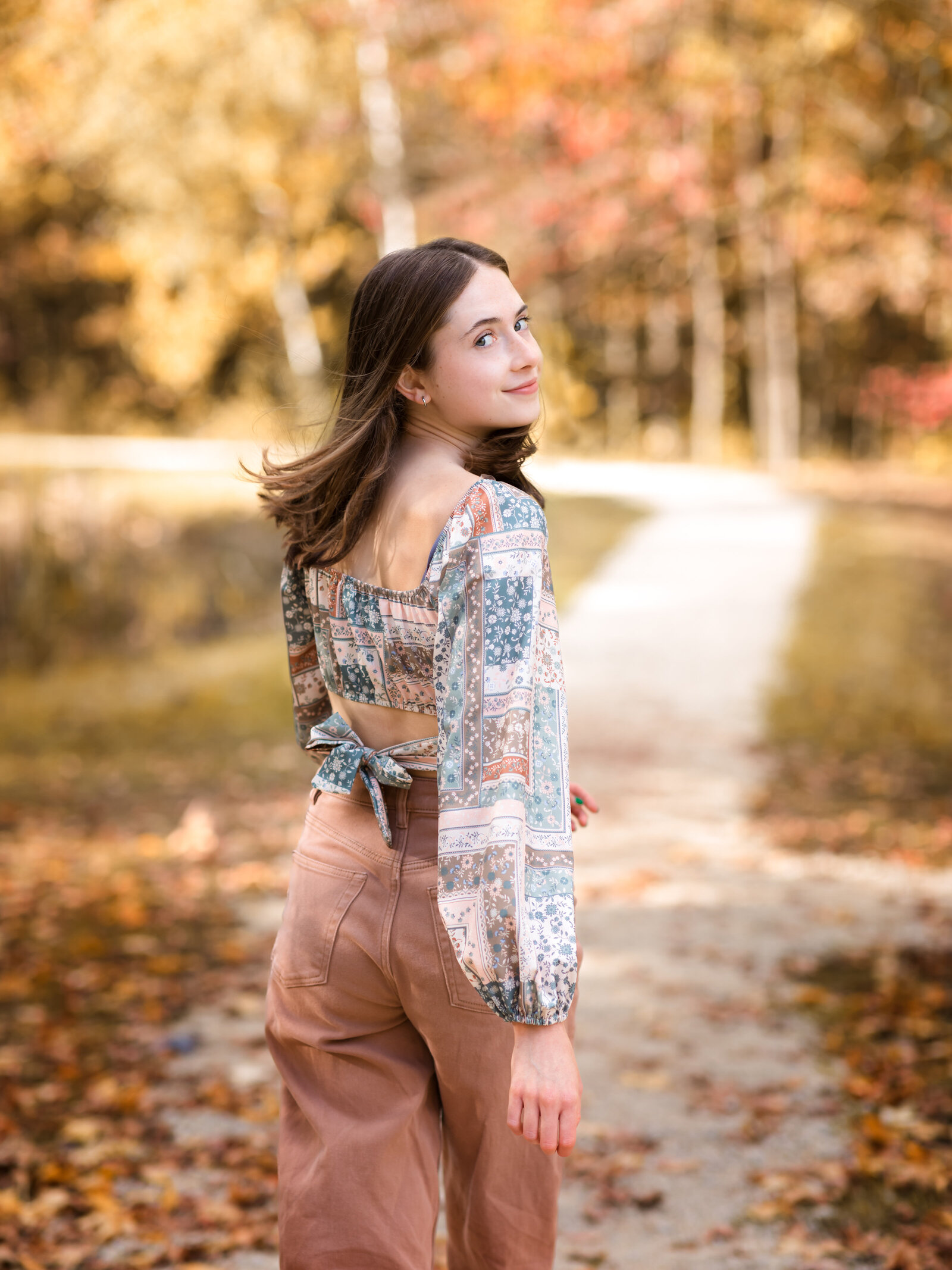 senior girl walking on path at park for senior portraits