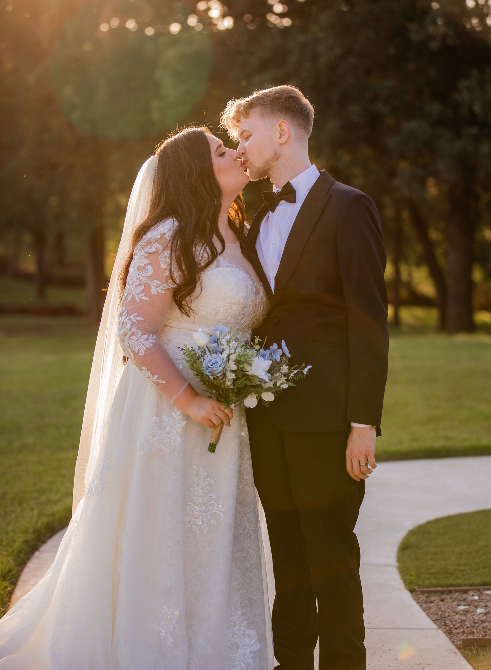 bride and groom kissing in the sunlight