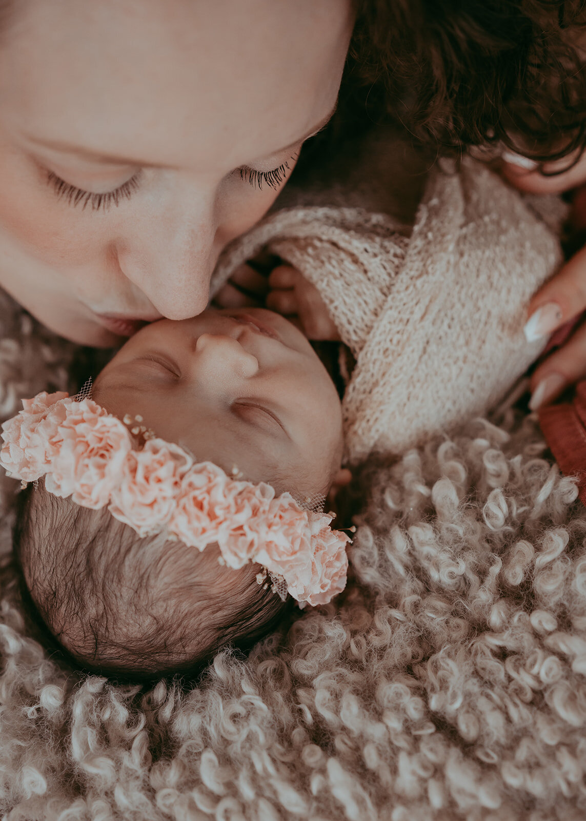 mother kisses newborn baby during studio session in parker colorado