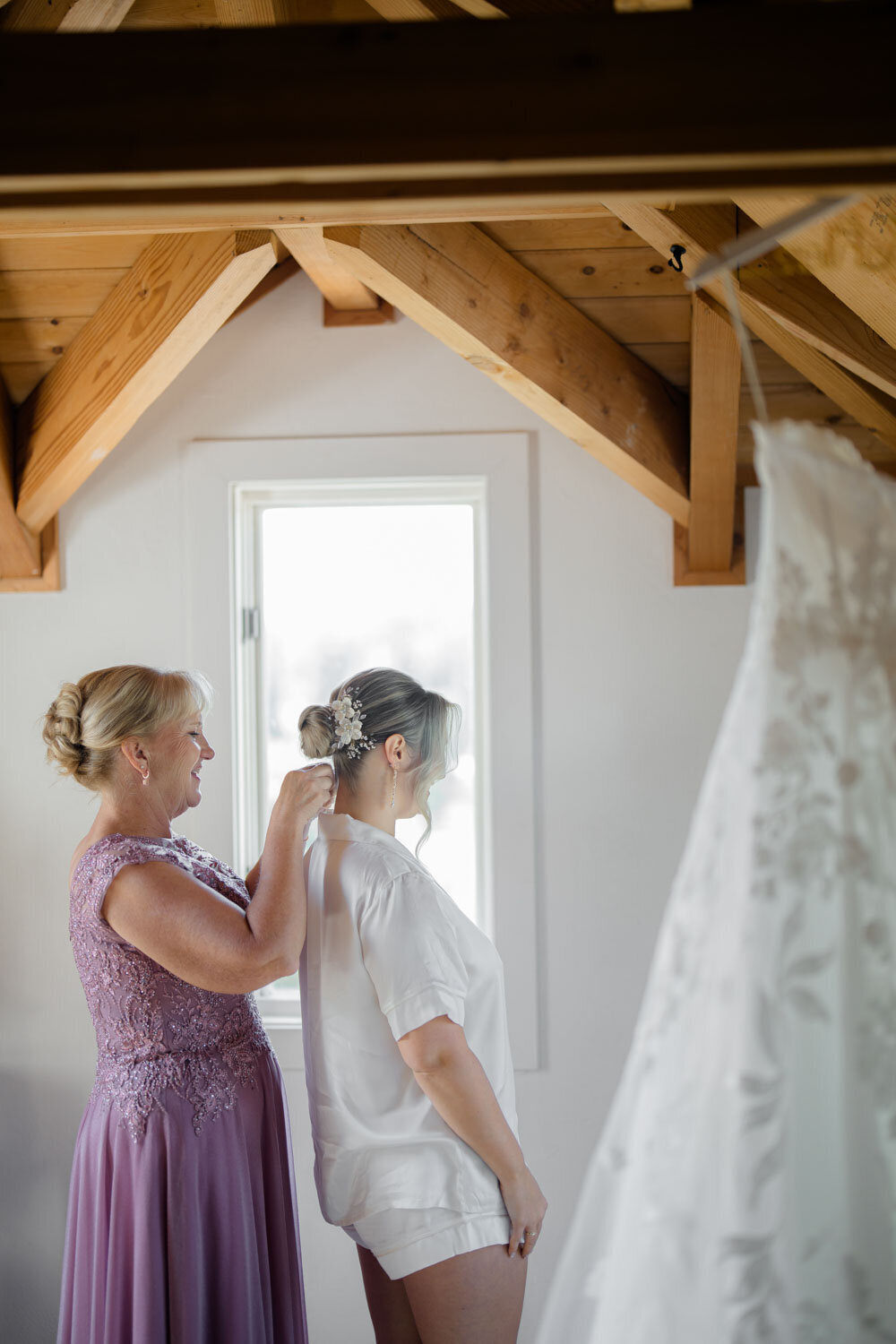 Mother adjusting the bride's veil in a cozy room
