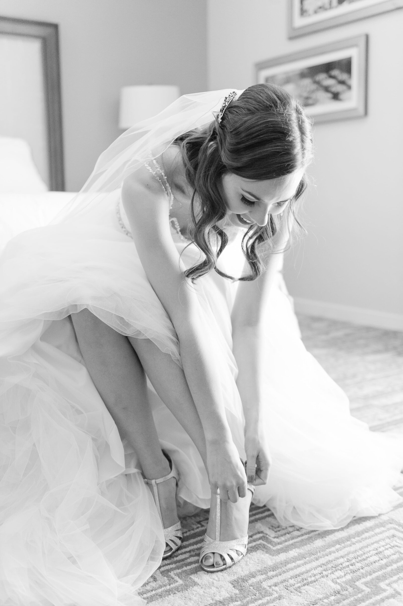 Bride putting shoes on at the Wigwam.