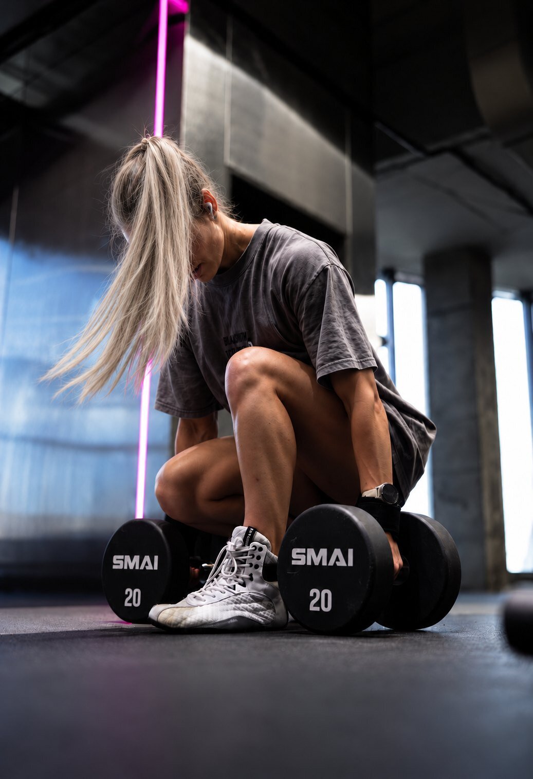 Woman resting between dumbbell sets