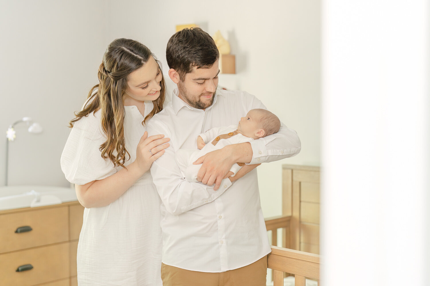 parents looking at baby adoringly in the nursery during newborn photo Great Falls, Virginia