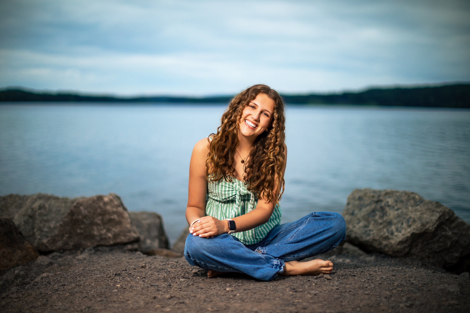 Girl smiles with the sparkling water behind her in this close-up portrait
